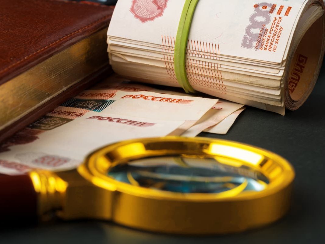 Увеличительное стекло на рублях российской валюты.